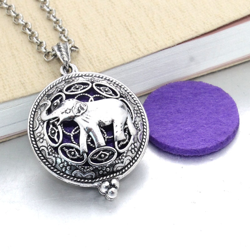 Aroma Essential Oil Diffuser Pendant Necklace with purple felt insert on a wooden surface, now considered a new fashion accessory.
