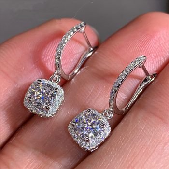 A woman holding a pair of Women's Crystal Drop Earrings.