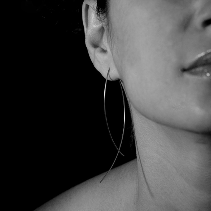 A black and white photo of a woman wearing Women's Curl Hoop Earrings.