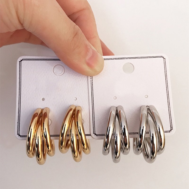 A person holding a pair of Women's Fashion Chunky Hoop Earrings.