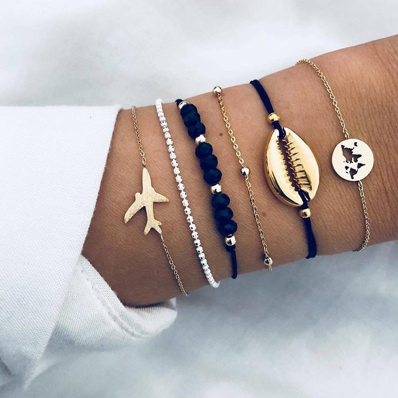 A collection of five Bohemian Rope Chain Bracelets around a wrist, featuring beads, charms, and gold accents, showcasing the latest in women's fashion accessories.