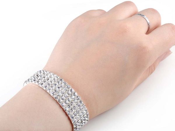 A hand adorned with a Full Rhinestone Elastic Bracelet for Women and a ring on the finger, showcasing the latest fashion trends.