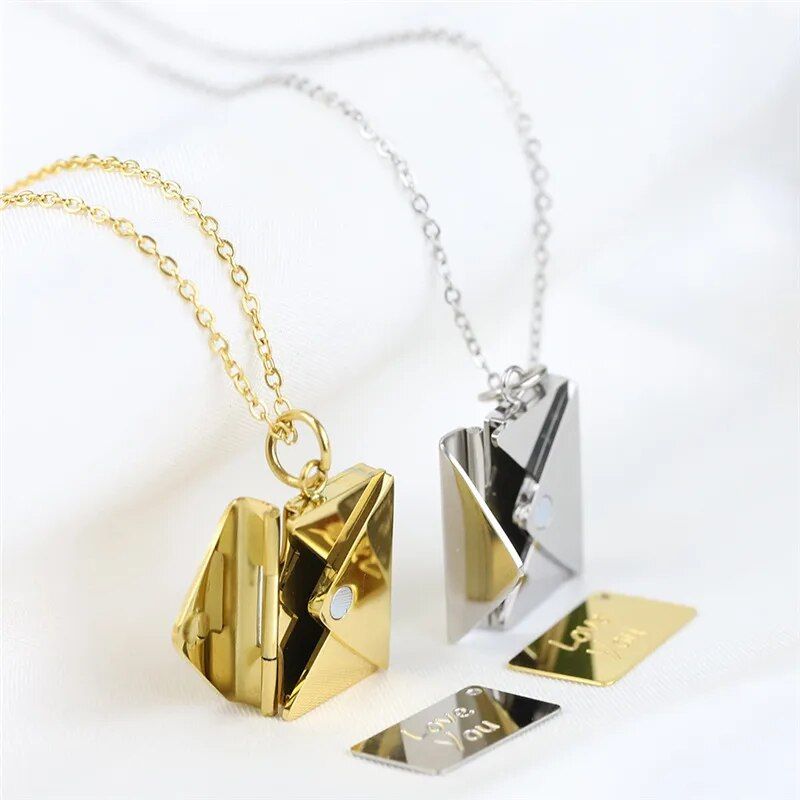 Love Letter Envelope pendant necklaces with small diamond accents on a white background, embodying new fashion trends.