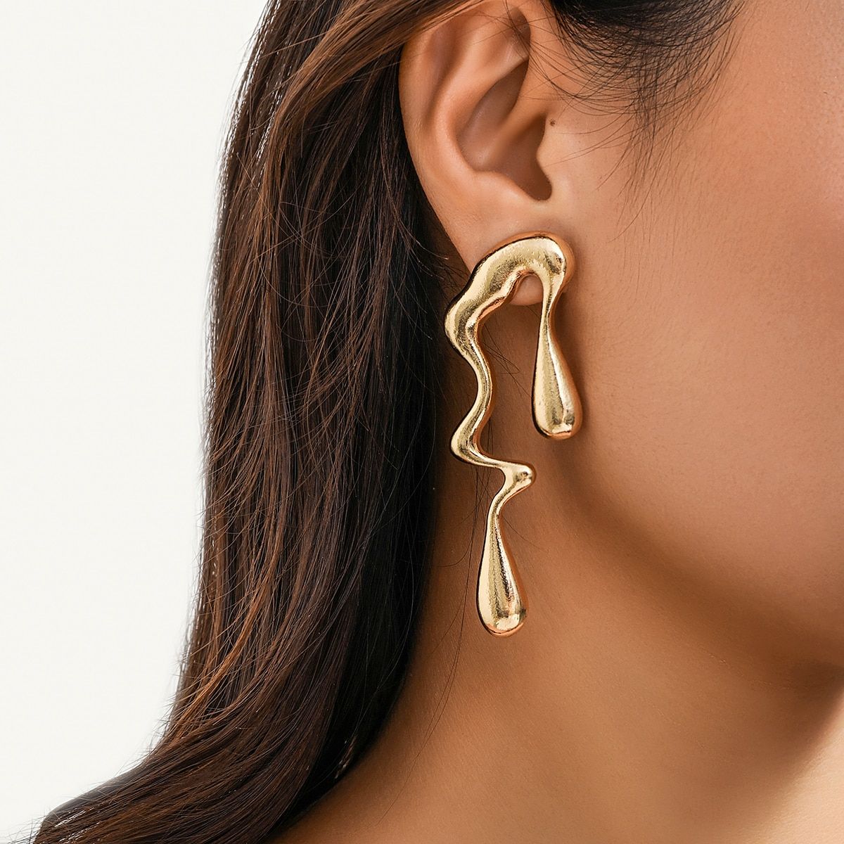Close-up of a woman's ear showcasing a unique, Vintage Gold Geometric Water Drop Earrings, a bold statement in women's fashion accessories.