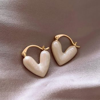 A pair of Elegant Heart Small Drop Earrings for Women, a perfect fashion accessory, on a silk fabric.