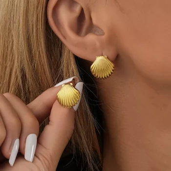 Close-up of a woman's hand adjusting a Vintage Shell Design Stud Earring, a new fashion accessory, on her ear.