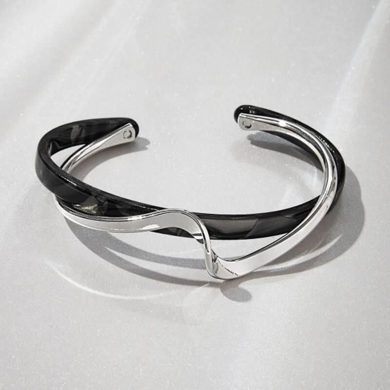 Geometric Metal Charm Bracelet for Women with a twisted design featuring black inlay accents, displayed on a white surface with light reflections. This piece is a chic fashion accessory for women's fashion.